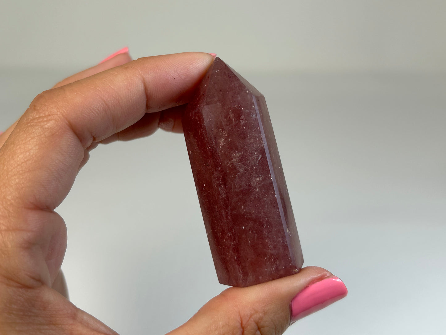 Hand holding a Red Aventurine Crystal Tower against a plain background