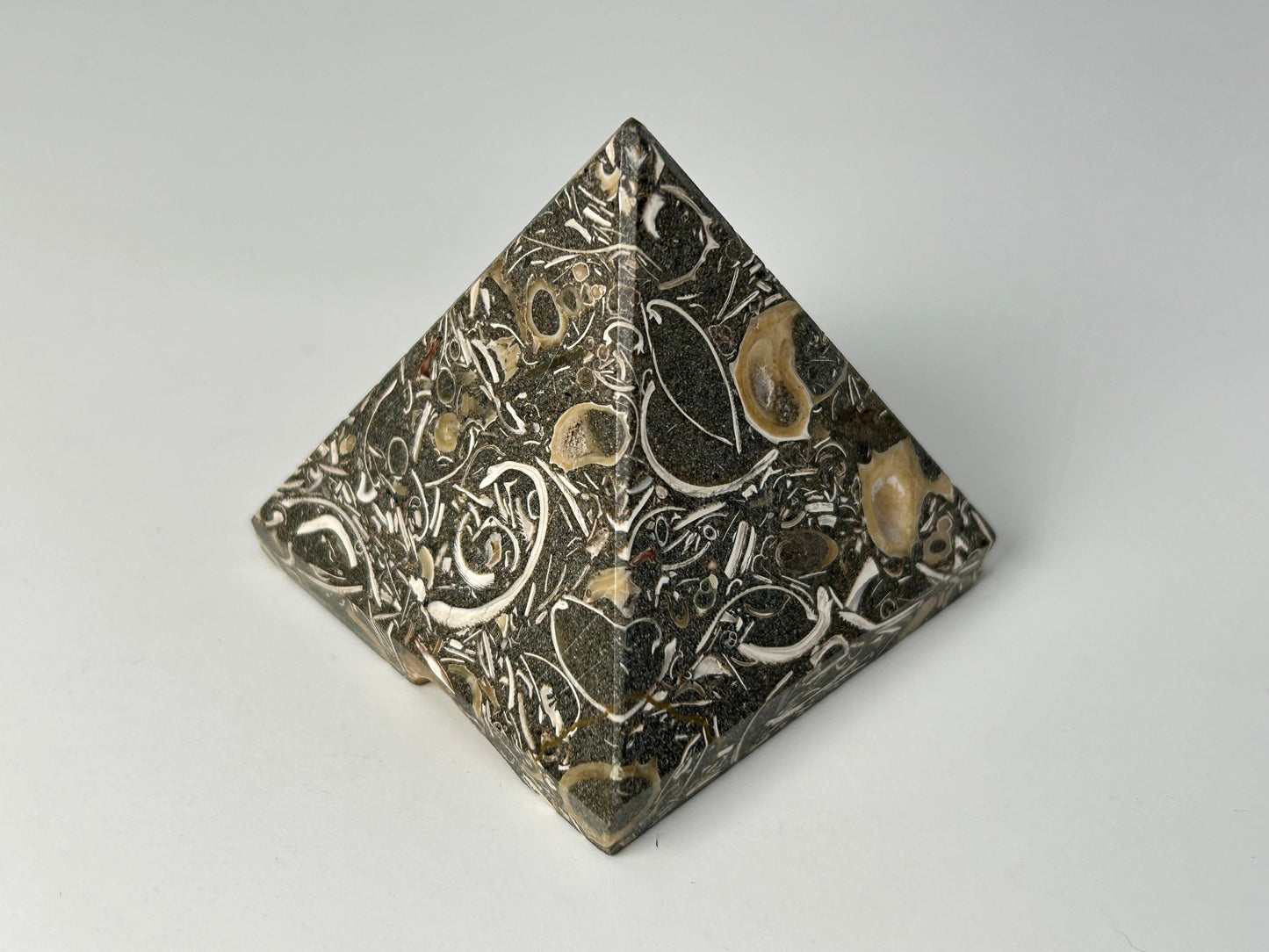 Ancient Turritella Agate Pyramid with decorative patterns on a gray background