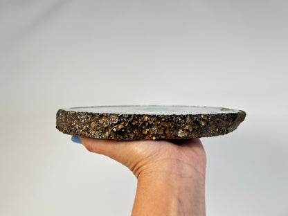 Hand holding an Aqua Blue Agate Geode Slice with gold trim for meditation and energy work with white background