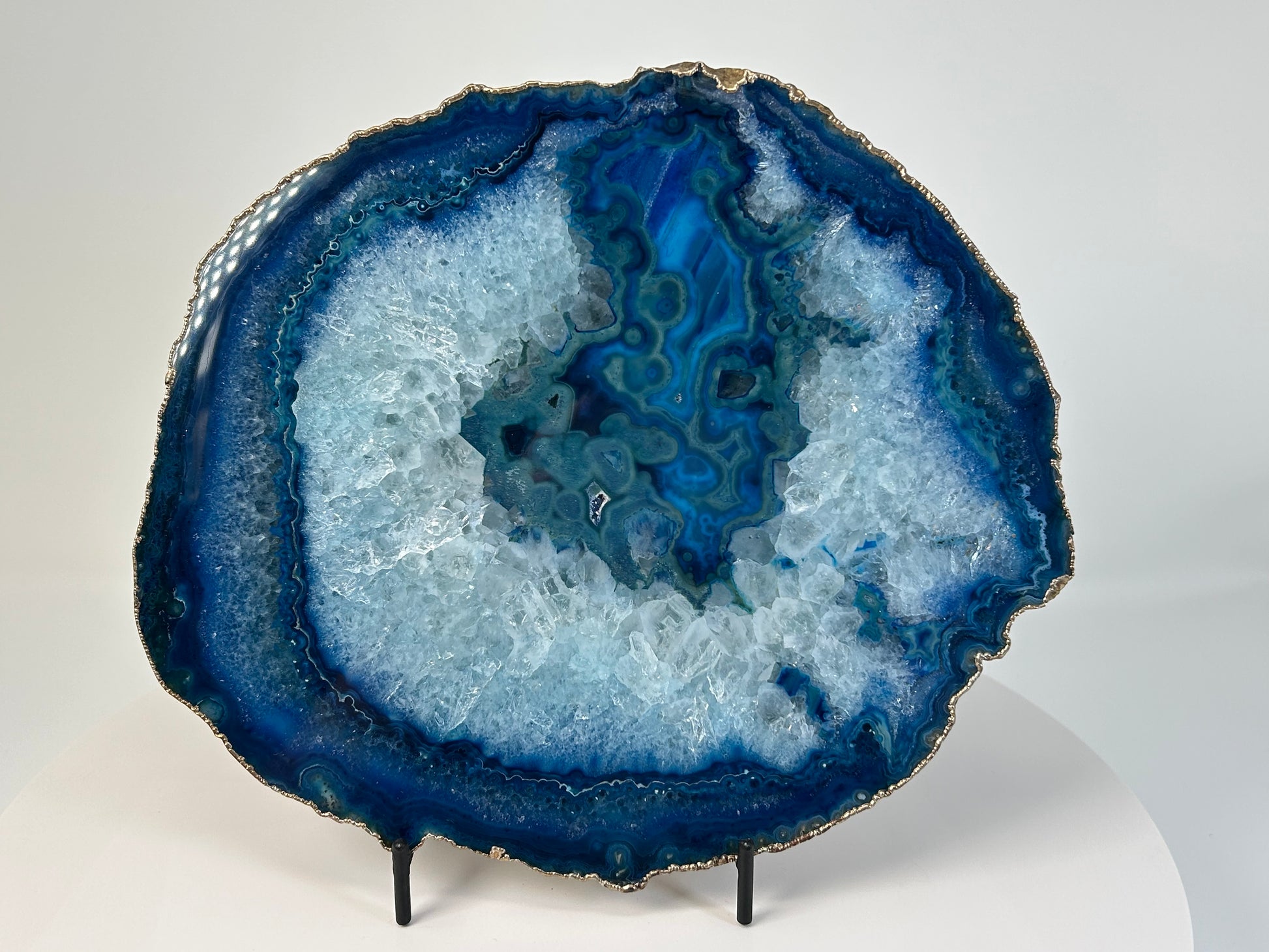 Blue Agate Stone Plate with gold trim for natural grounding on table stand with white background 