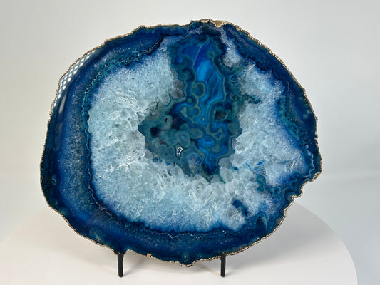 Blue Agate Stone Plate with gold trim for natural grounding on table stand with white background 