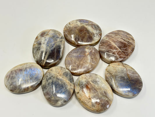 Set of polished Blue Moonstone with Sunstone Palm Stones on a white background