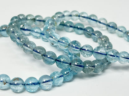 String of light Blue Topaz Bracelet beads for meditation mindfulness and grounding with a white background