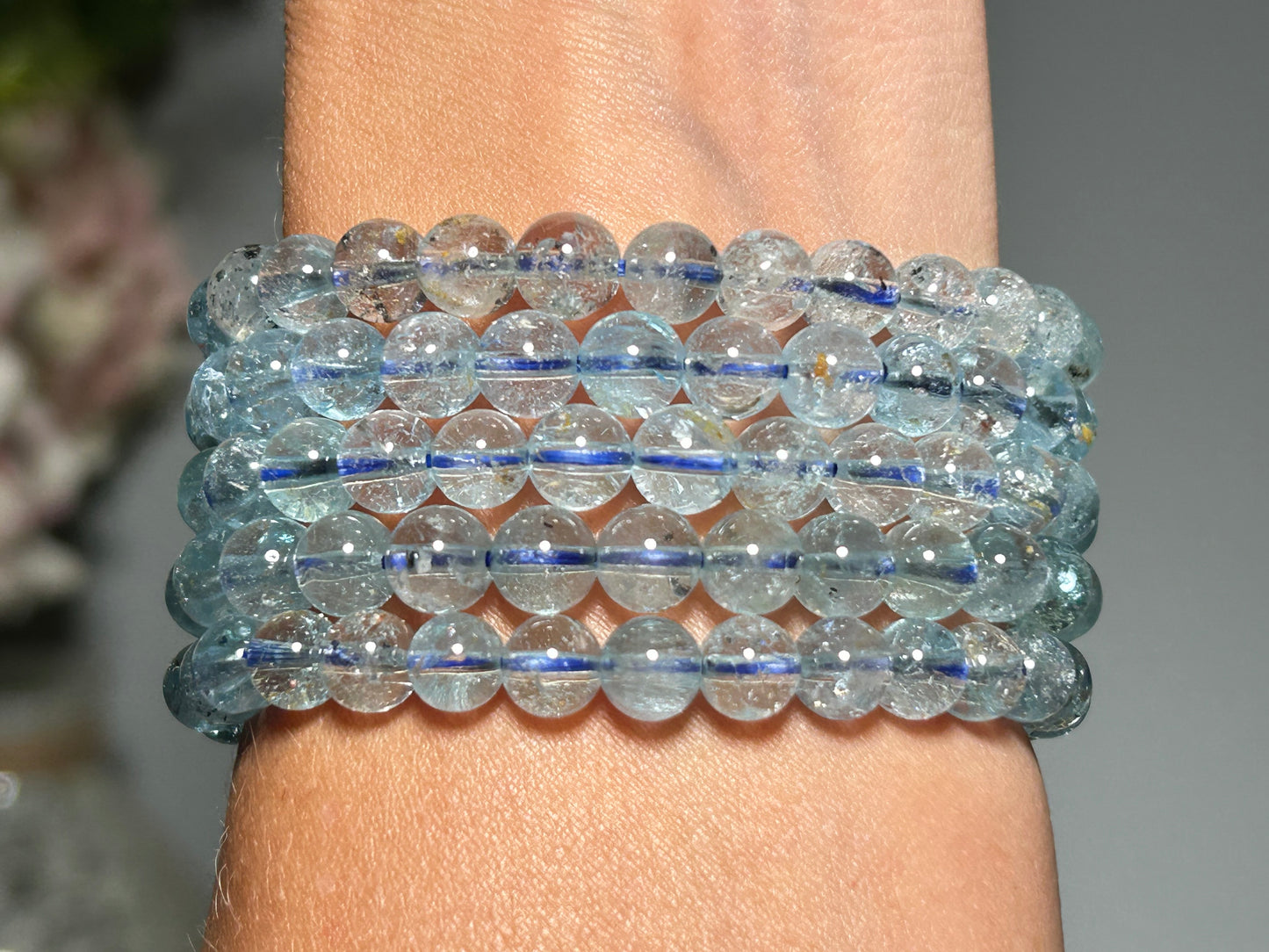 Stack of Blue Topaz Bracelets for meditation mindfulness and grounding on a wrist with a blurred background