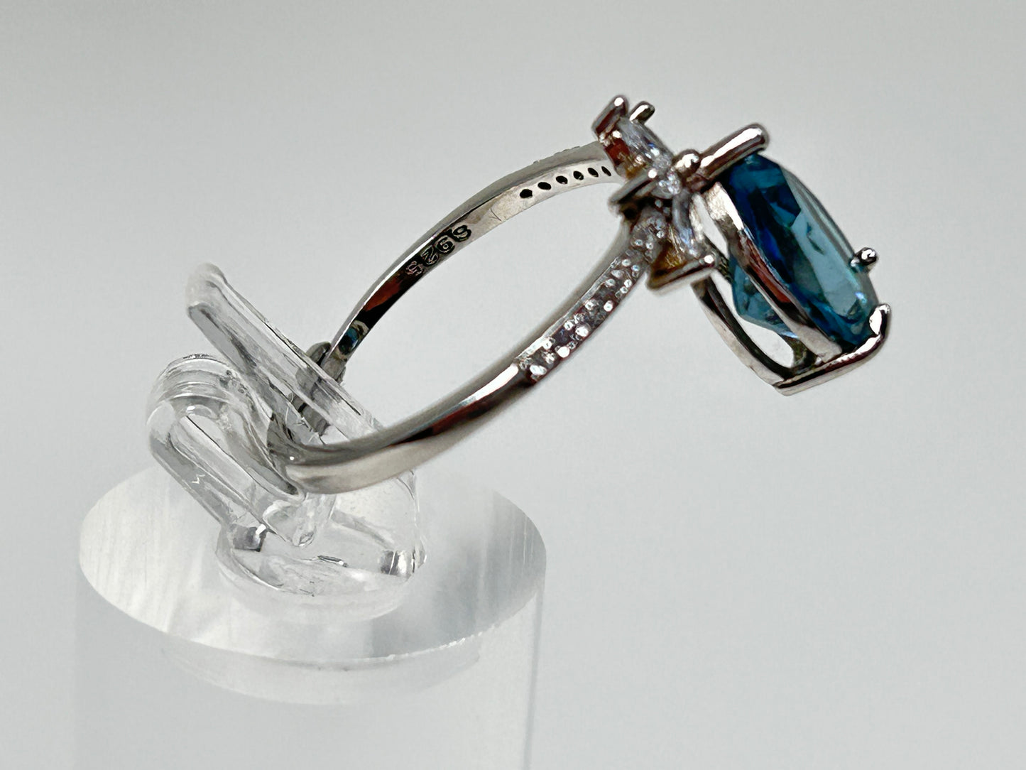 Blue Topaz Ring with Cubic Zirconia in Sterling Silver on table stand with white background. 