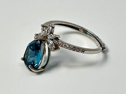 Blue Topaz Ring with Cubic Zirconia in Sterling Silver on a light gray background