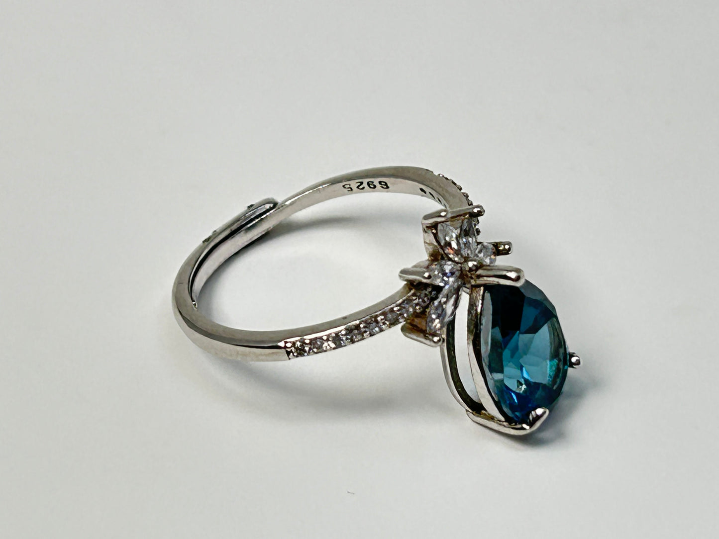Blue Topaz Ring with Cubic Zirconia in Sterling Silver on a light gray background