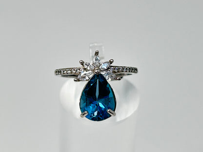 Close up of a Blue Topaz Ring with Cubic Zirconia in Sterling Silver for meditation and energy work with white gray background