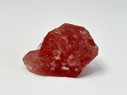 Natural Cherry Tanzurine Quartz for energy healing on table with white background.
