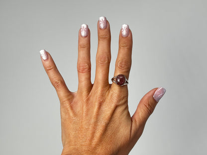Hand wearing a Cherry Tanzurine Sterling Silver Ring for meditation and energy work with white background.