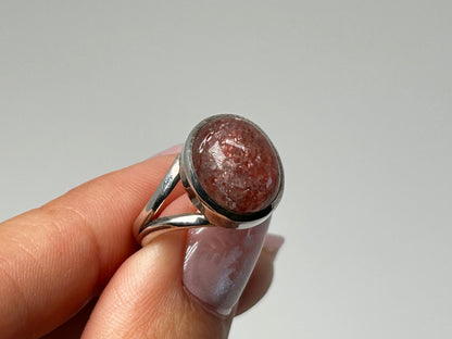 Hand holding Cherry Tanzurine Sterling Silver Ring with white background.