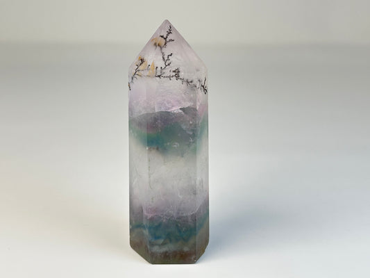 Dendritic Fluorite Tower gemstone on table stand with white background.