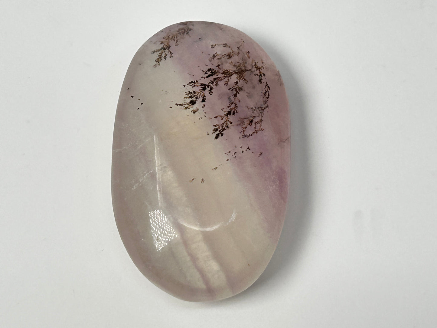 Oval-shaped Dendritic Fluorite in table with purple and white hues on a white background