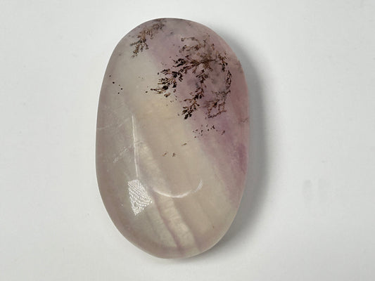 Oval-shaped Dendritic Fluorite in table with purple and white hues on a white background