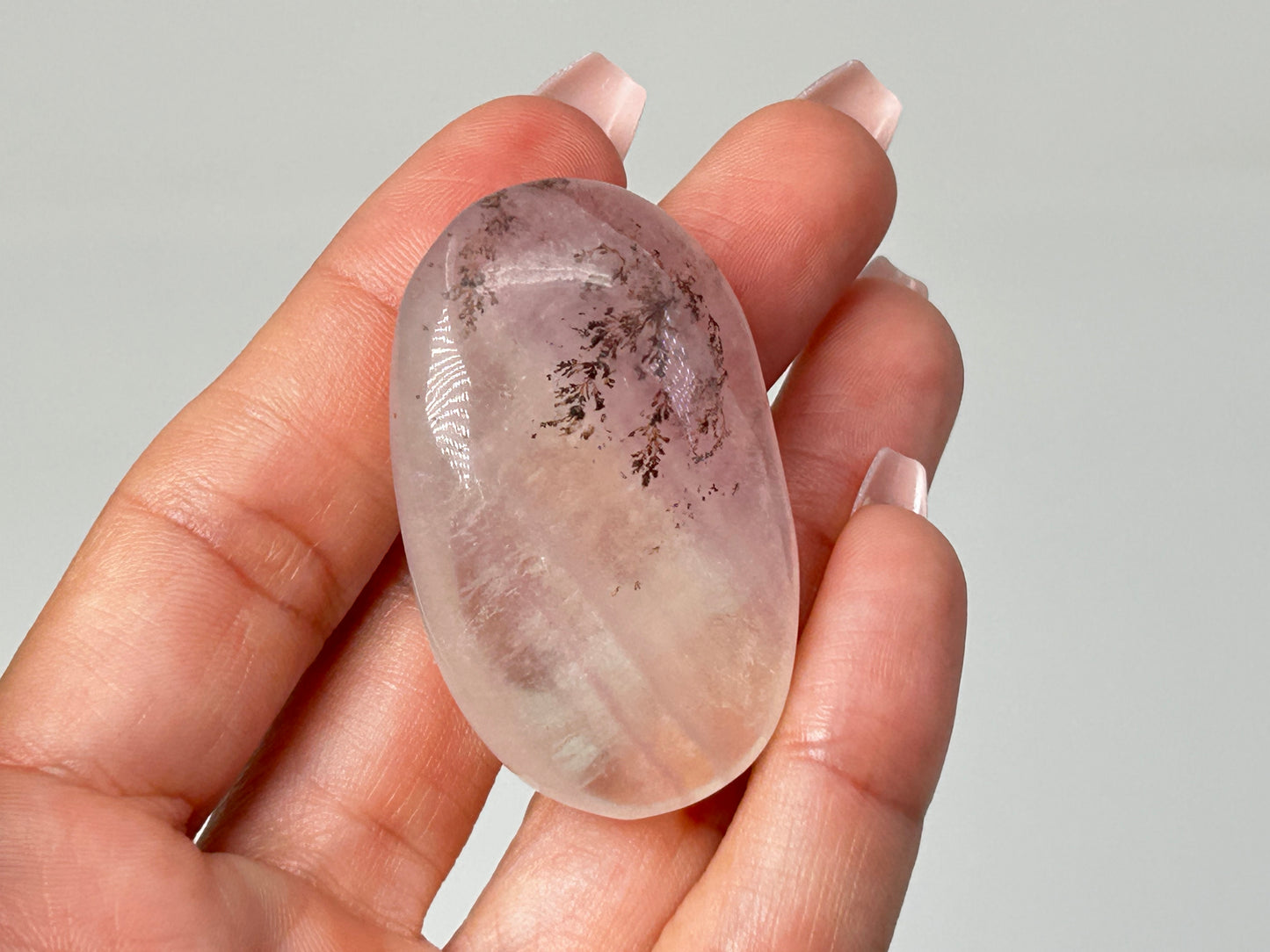 Hand holding Oval-shaped Dendritic Fluorite meditation healing crystal ethically sourced gemstone.