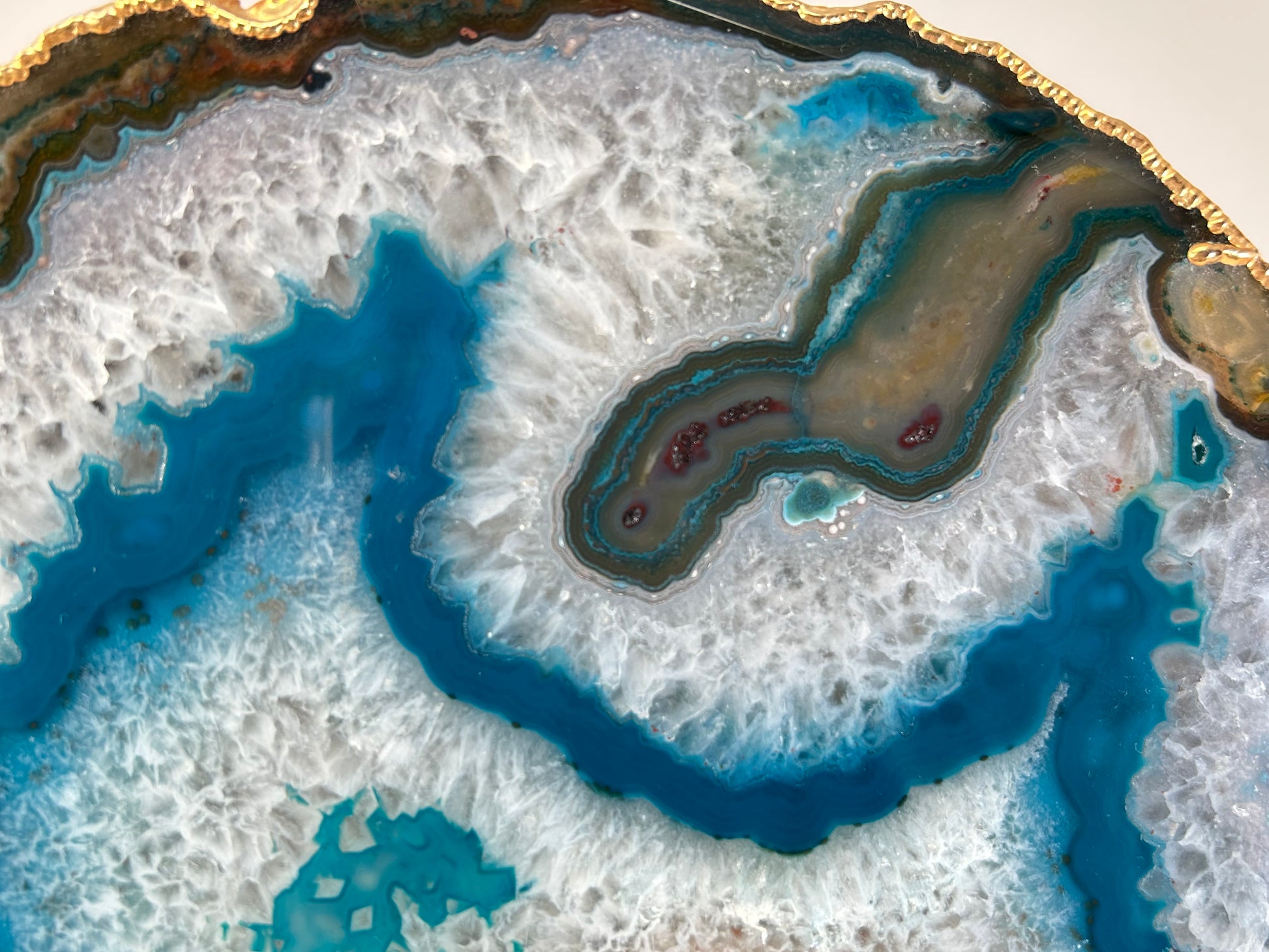 Close-up of Dyed Blue Agate Plate geode with blue and brown mineral deposits