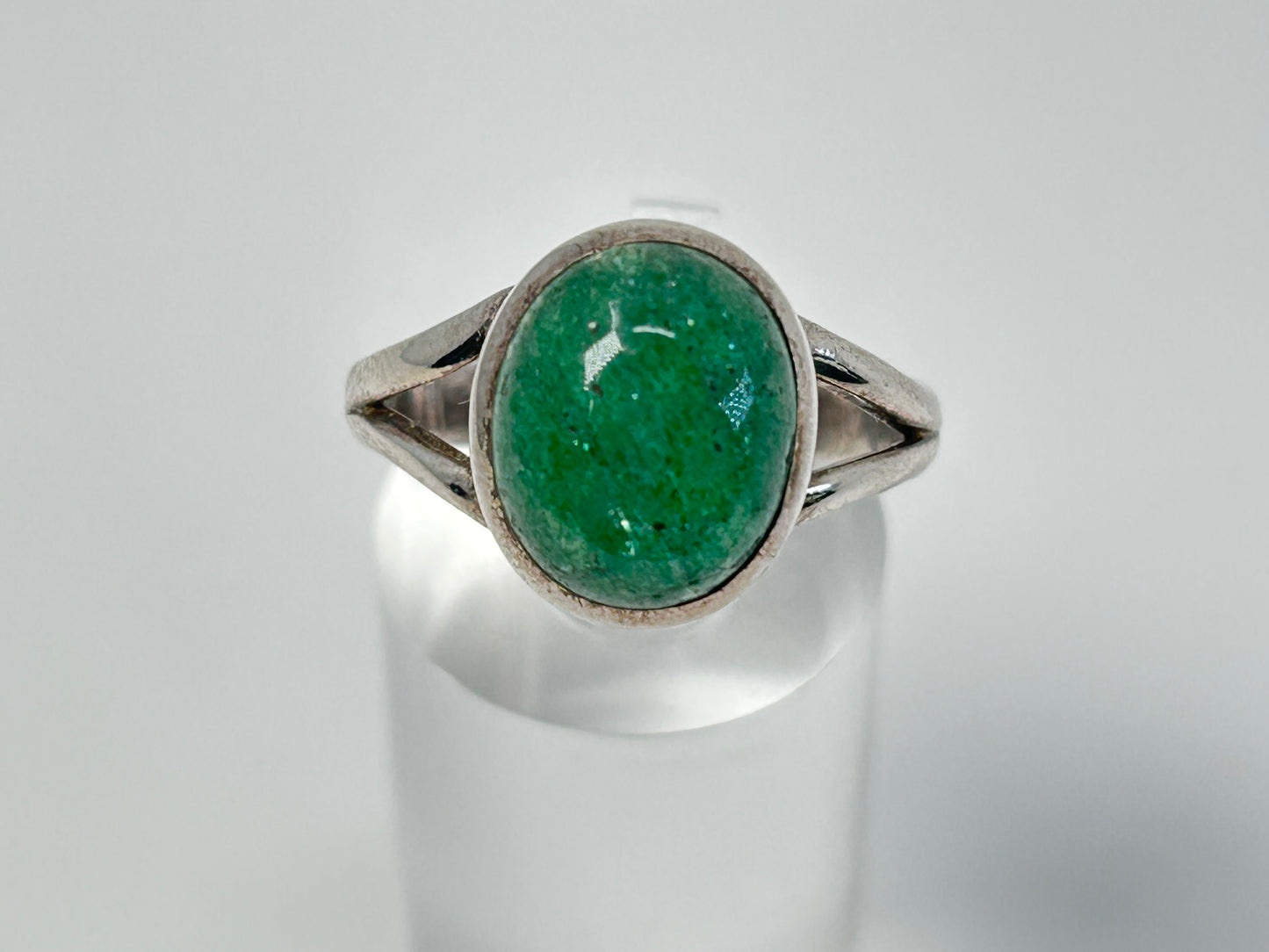 Emerald Tanzurine Sterling Silver Ring for natural grounding on table with white background.