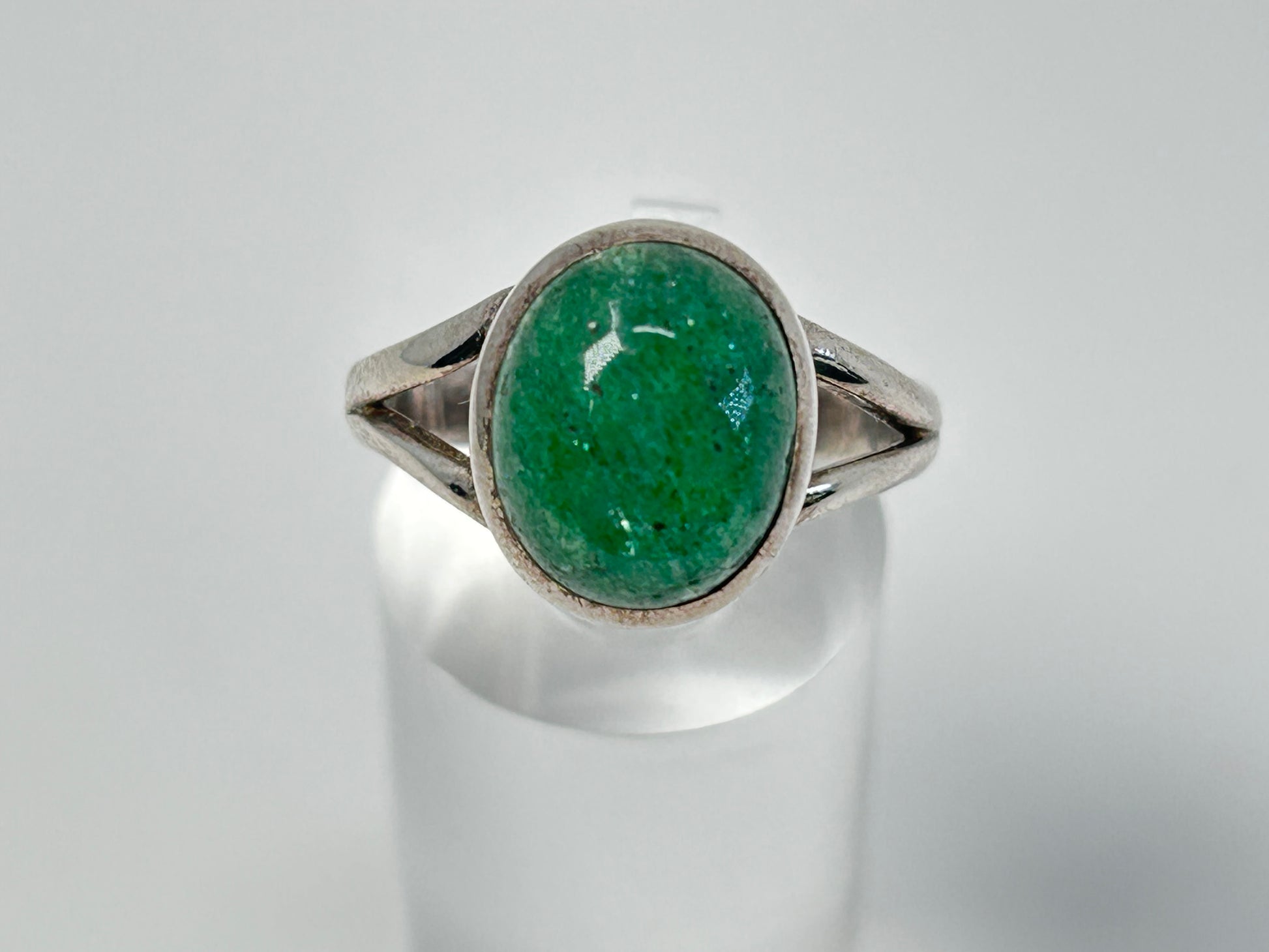 Emerald Tanzurine Sterling Silver Ring for natural grounding on table with white background.