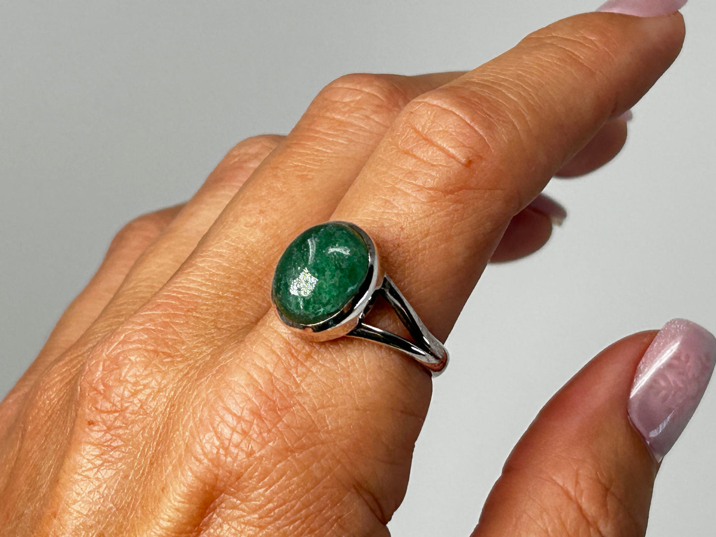Hand wearing an Emerald Tanzurine Sterling Silver Ring for meditation and energy work with white background.