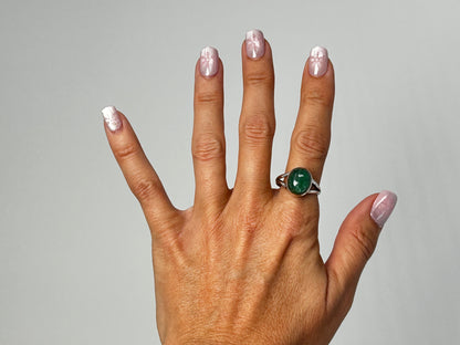 Hand wearing a Emerald Tanzurine Sterling Silver Ring on  a gray background