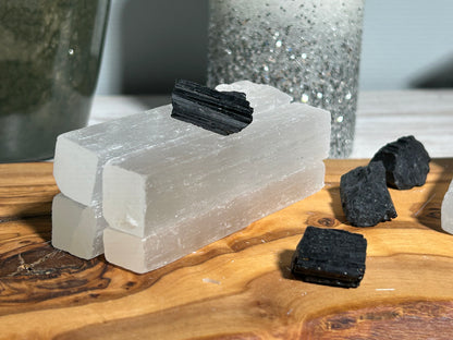 Home Protection Kit with four Selenite Sticks and one Black Tourmaline on a wooden surface with a blurred background