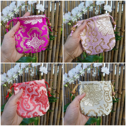 Hand holding Kids Mystery Crystal Bag-Childhood Memories Collection bags for natural grounding with bamboo and flower background