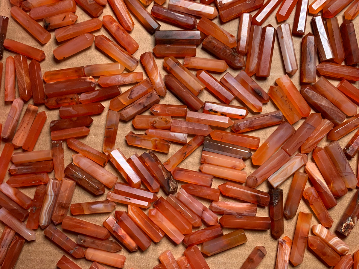 Mini Carnelian Crystal Towers for energy and trust on a tan background.