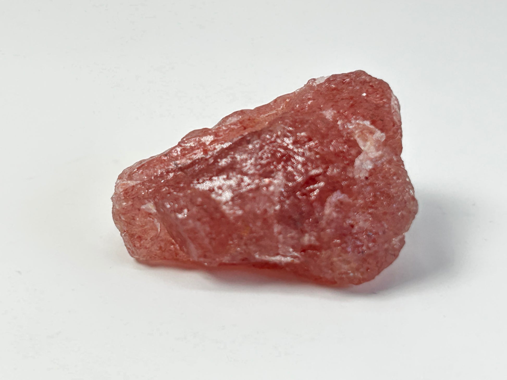 Natural Cherry Quartz Tanzurine Chunk on table top with white background