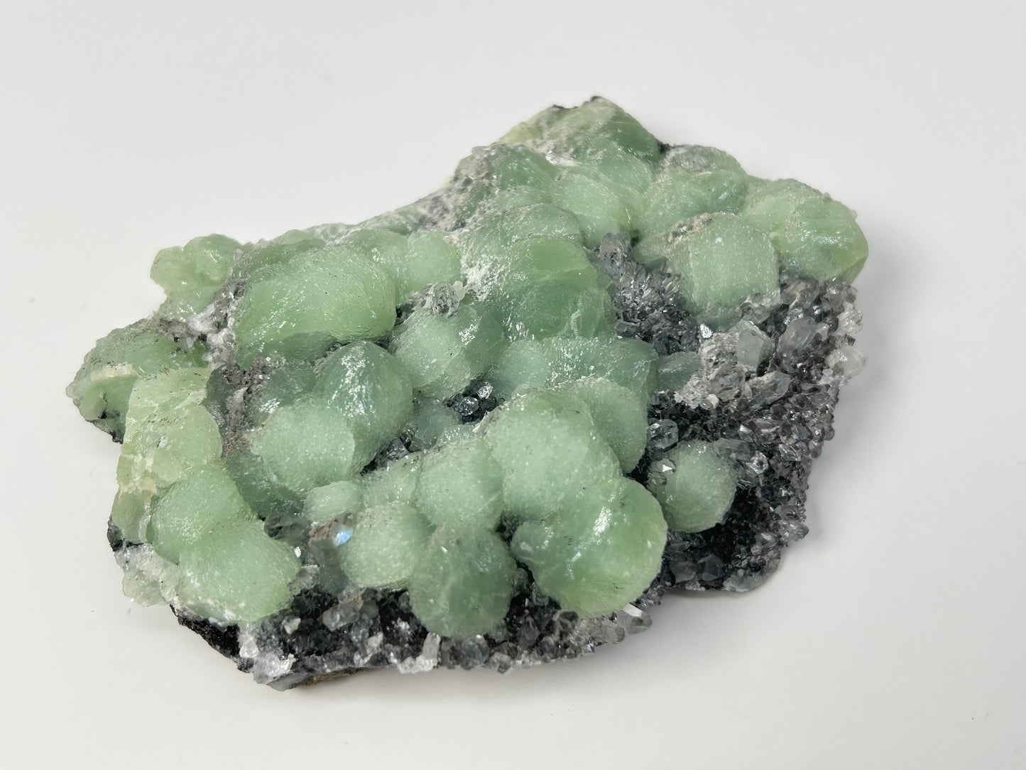 Green mineral specimen of Prehnite on Quartz Cluster meditation healing crystal ethically sourced gemstone.on a white background.