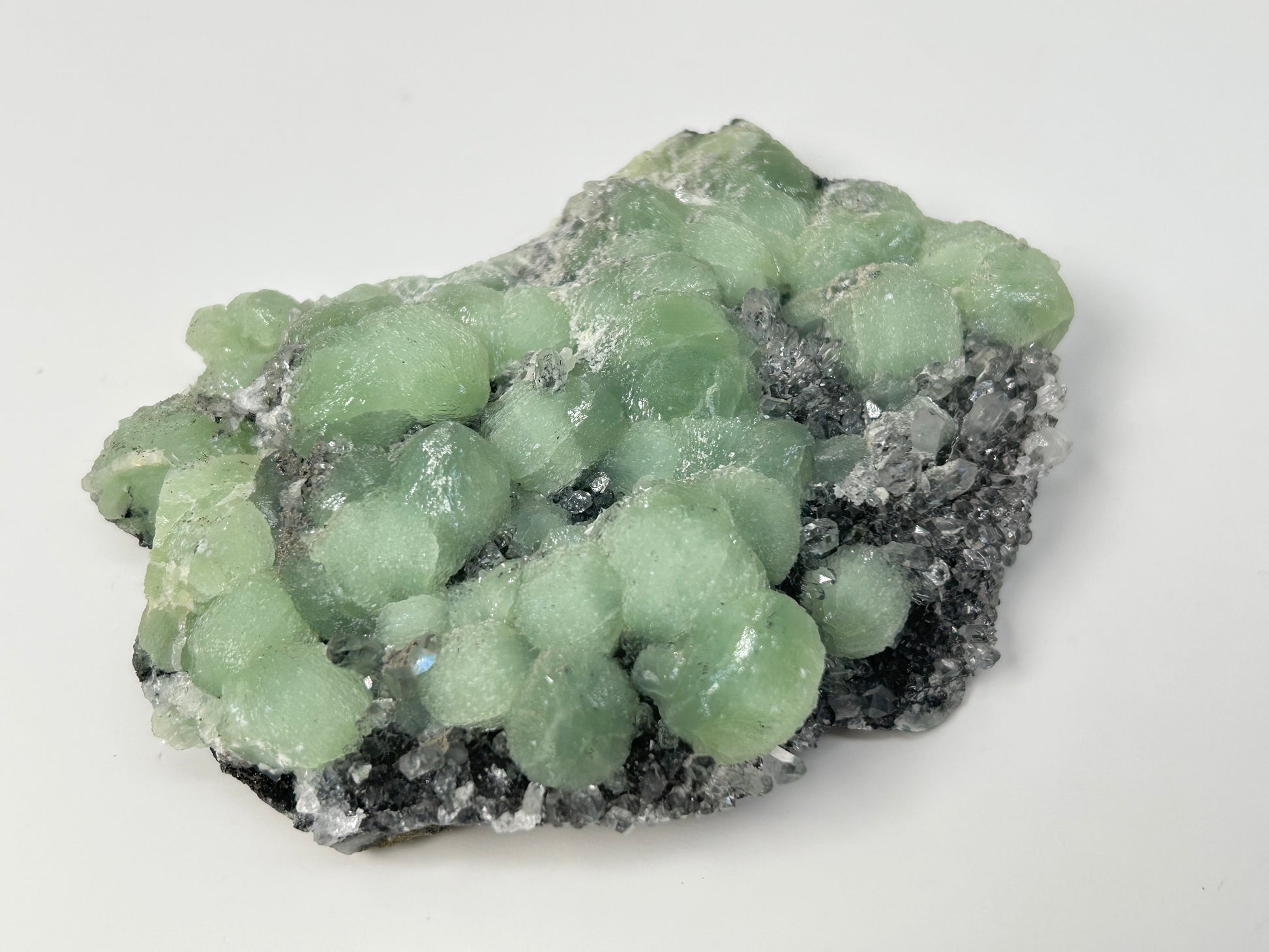 Green mineral specimen of Prehnite on Quartz Cluster meditation healing crystal ethically sourced gemstone.on a white background.