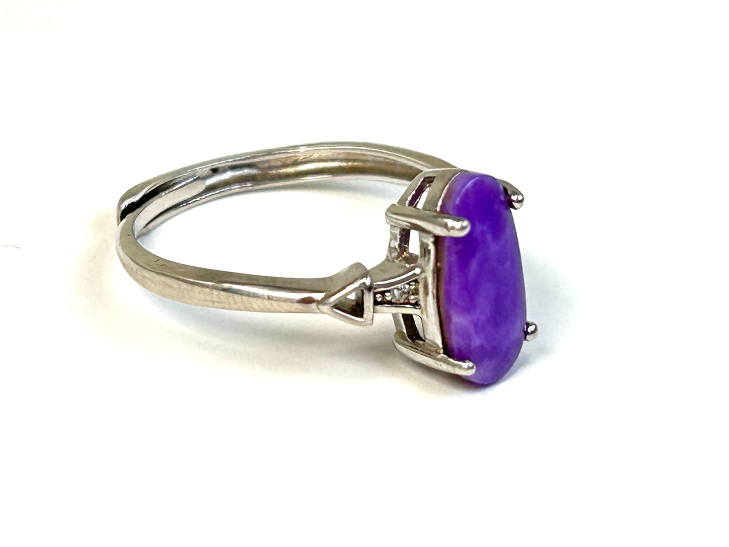Purple Sugilite Crystal in Sterling Silver Ring with Cubic Zirconia for natural grounding on table with white background
