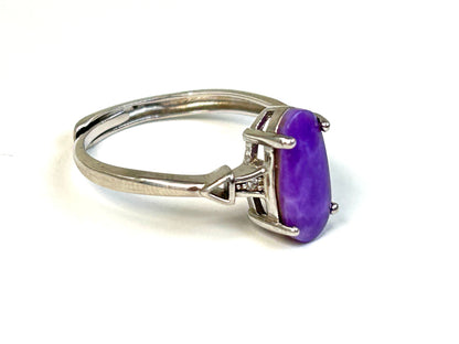 Purple Sugilite Crystal in Sterling Silver Ring with Cubic Zirconia for natural grounding on table with white background
