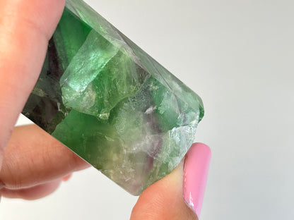 Close up of a Rainbow Fluorite Tower gemstone for meditation and energy work with white background