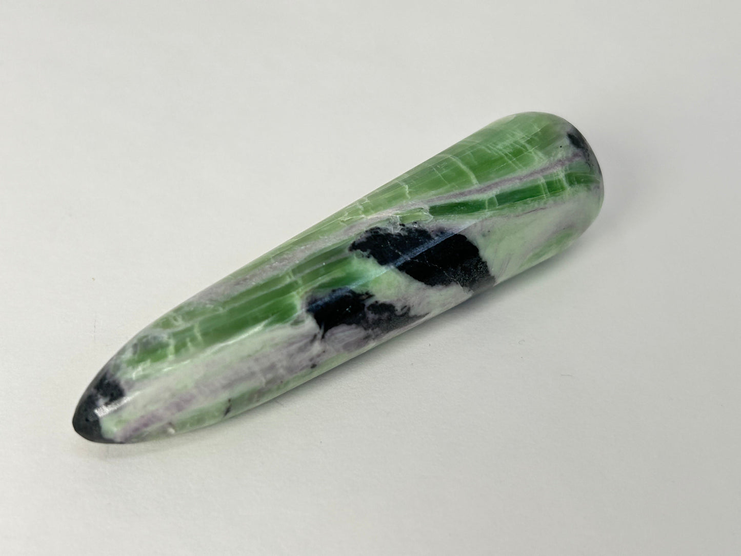 A polished Rare Green and Purple Kammererite Wand featuring natural green, black, and white marbled patterns, photographed on a plain light gray background.