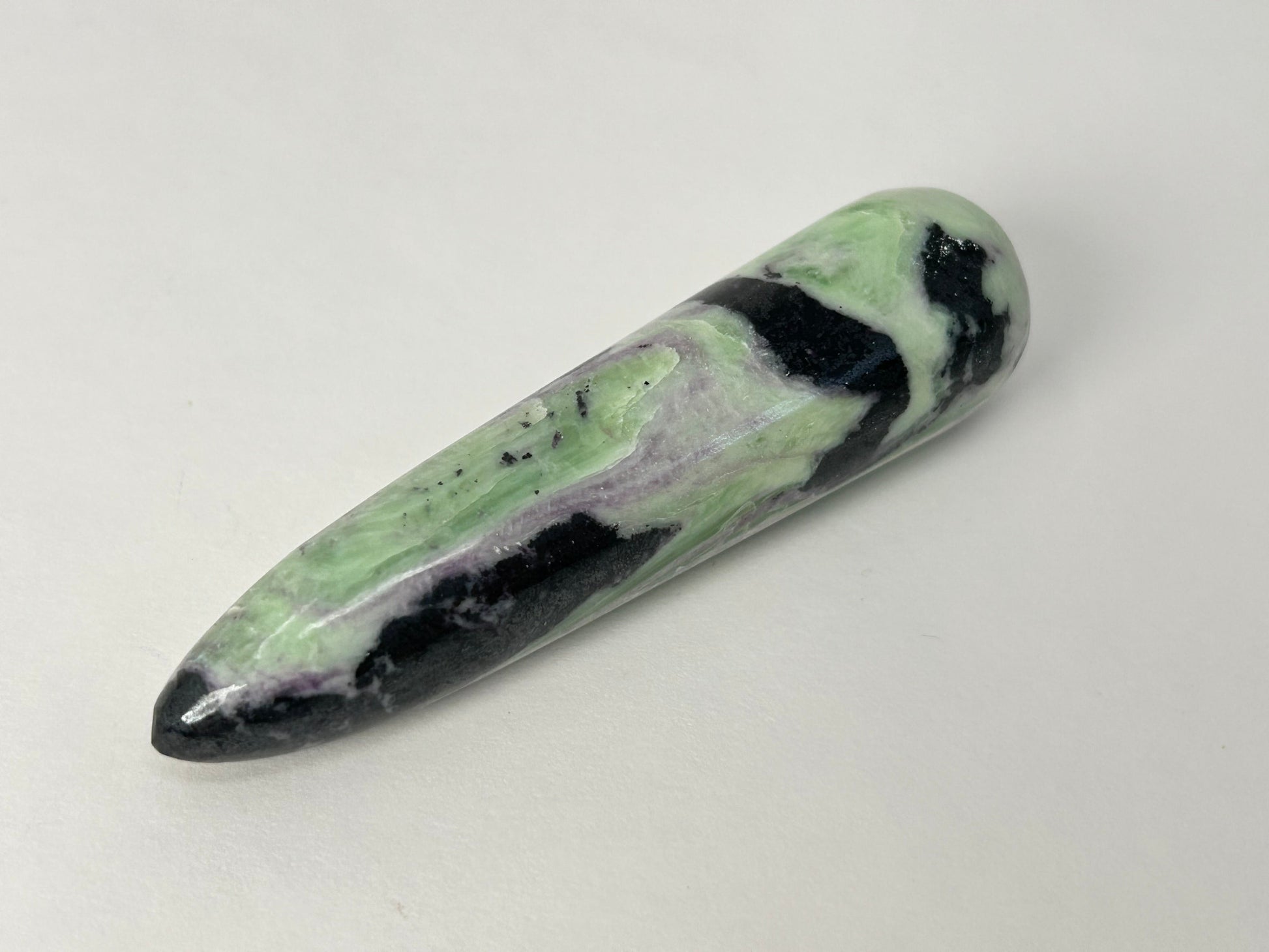 A polished Rare Green and Purple Kammererite Wand featuring a marbled pattern of light green, black, and white, photographed on a plain off-white background.