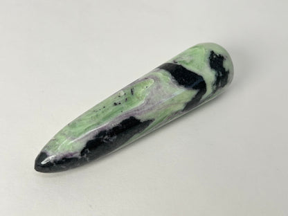 A polished Rare Green and Purple Kammererite Wand featuring a marbled pattern of light green, black, and white, photographed on a plain off-white background.