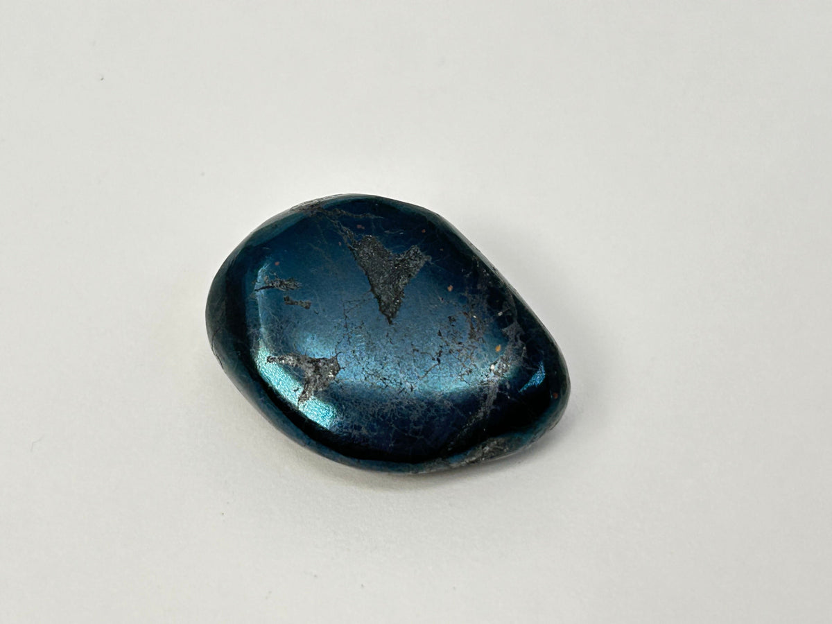 A polished dark blue Rare Healing Covellite Stone with a metallic sheen and natural inclusions, photographed on a plain light background.
