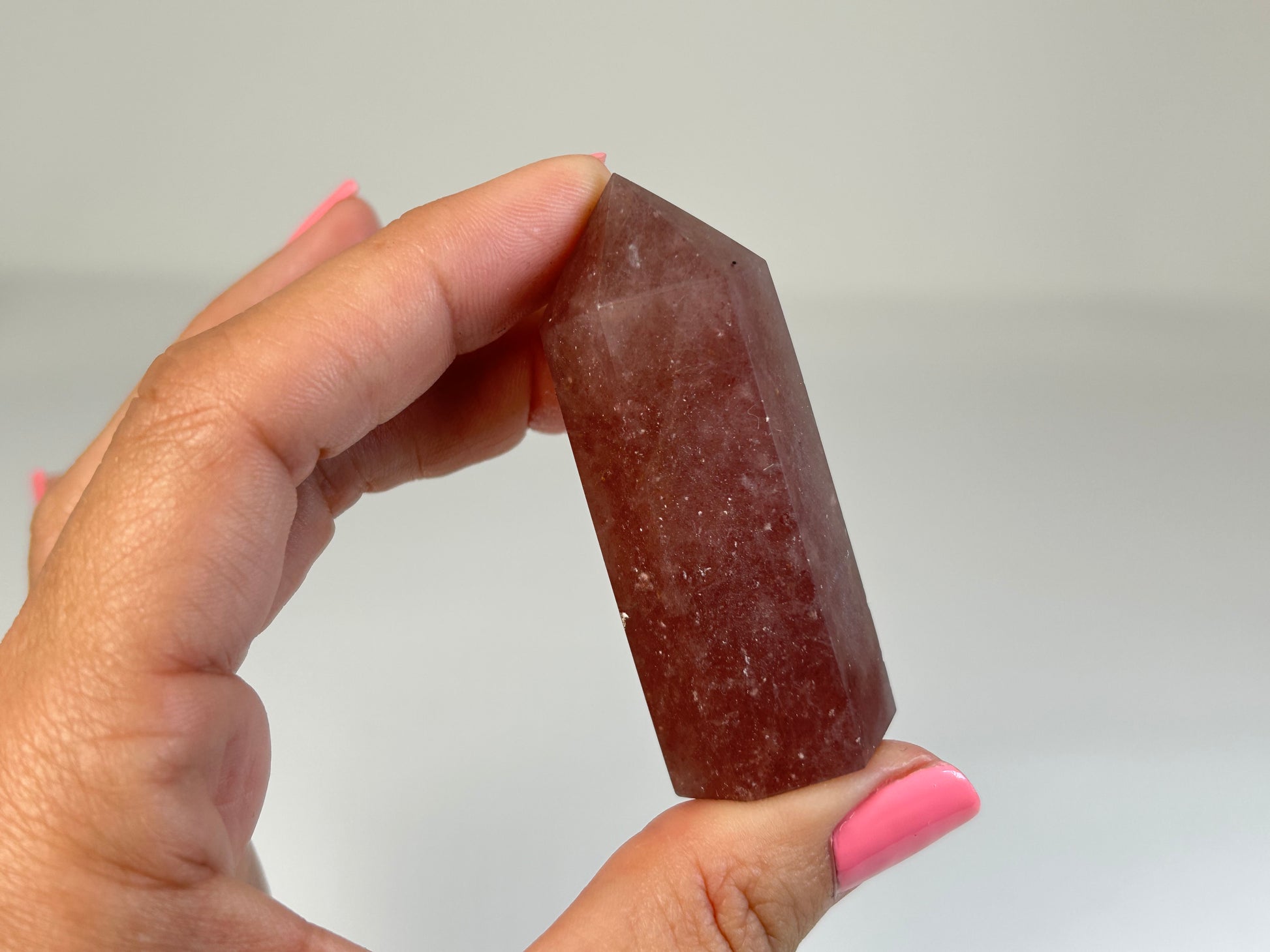 Hand holding a Red Aventurine Crystal Tower against a plain background