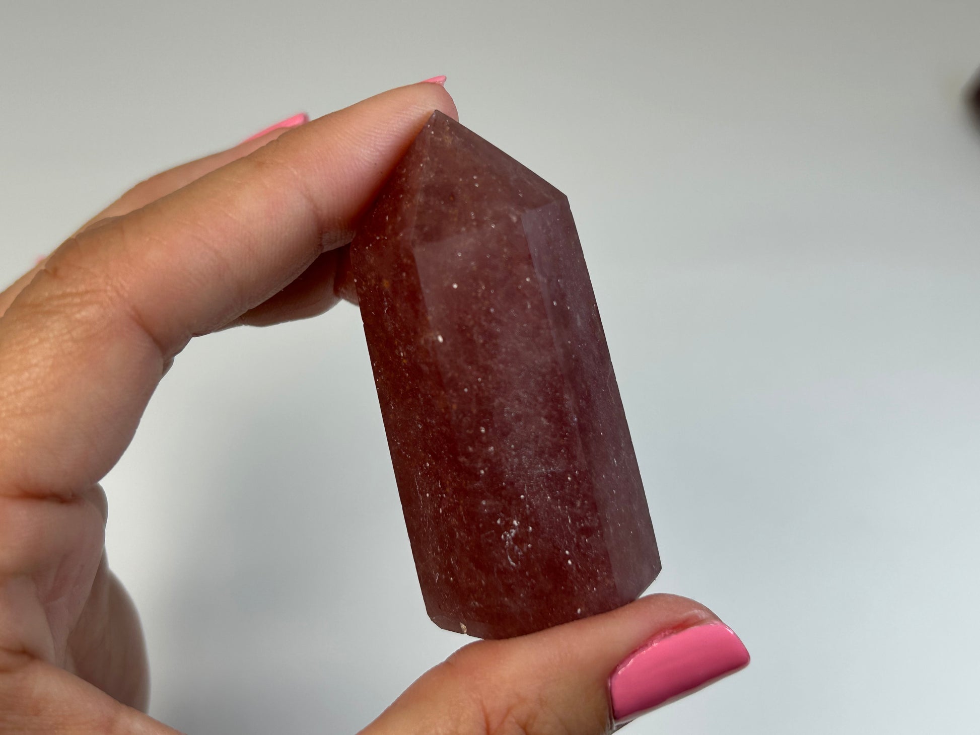 Hand holding a Red Aventurine Crystal Tower against a plain background