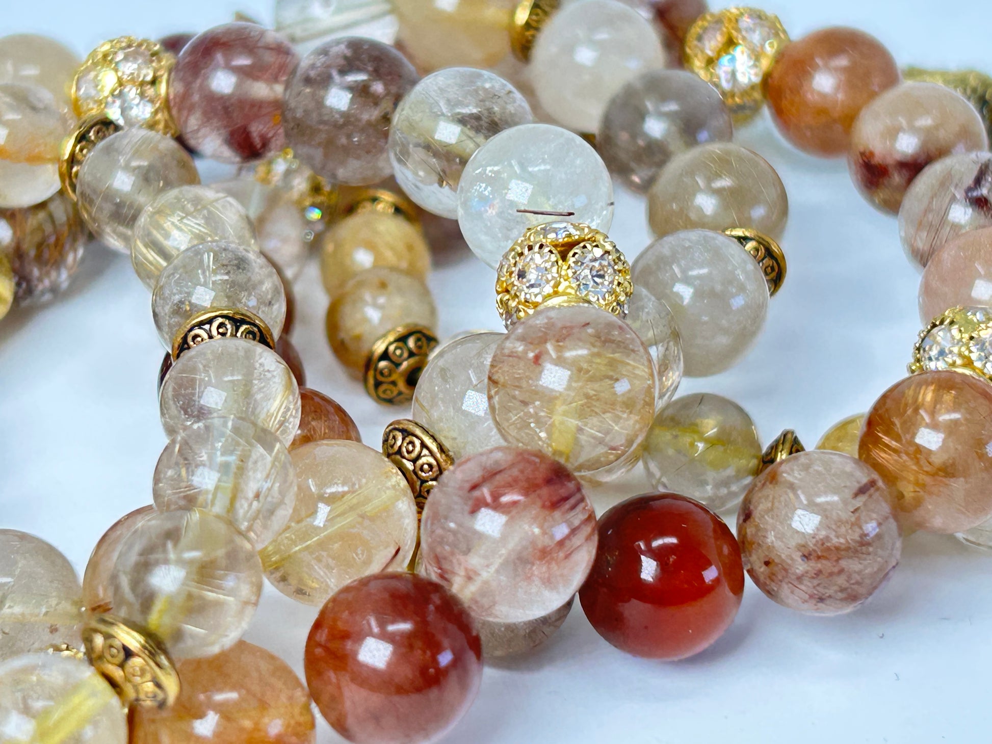 Close-up of a beaded necklace with multicolored beads and gold accents on a white background