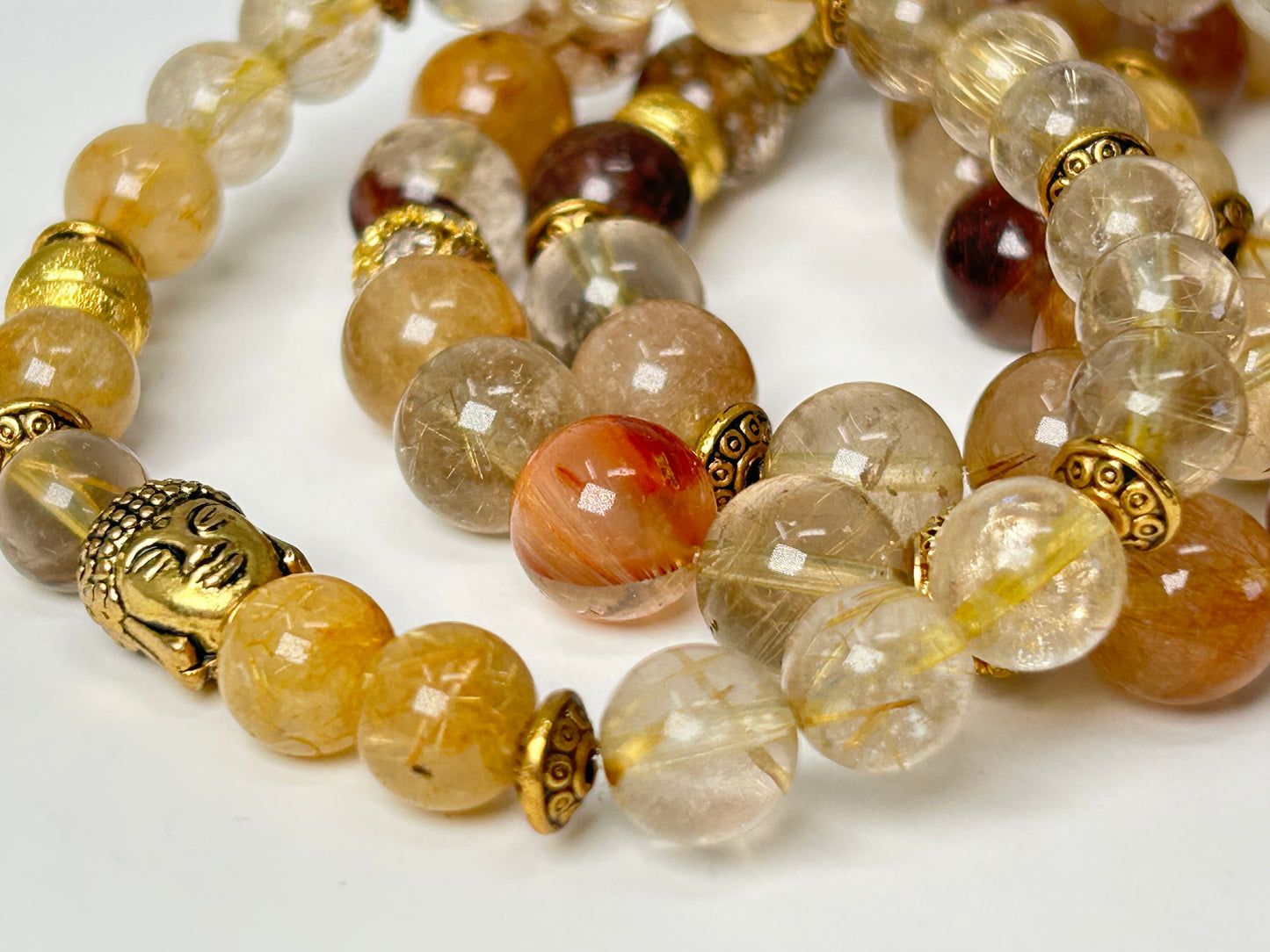Close-up of Rutile Quartz Bracelets with gold accents on a white background