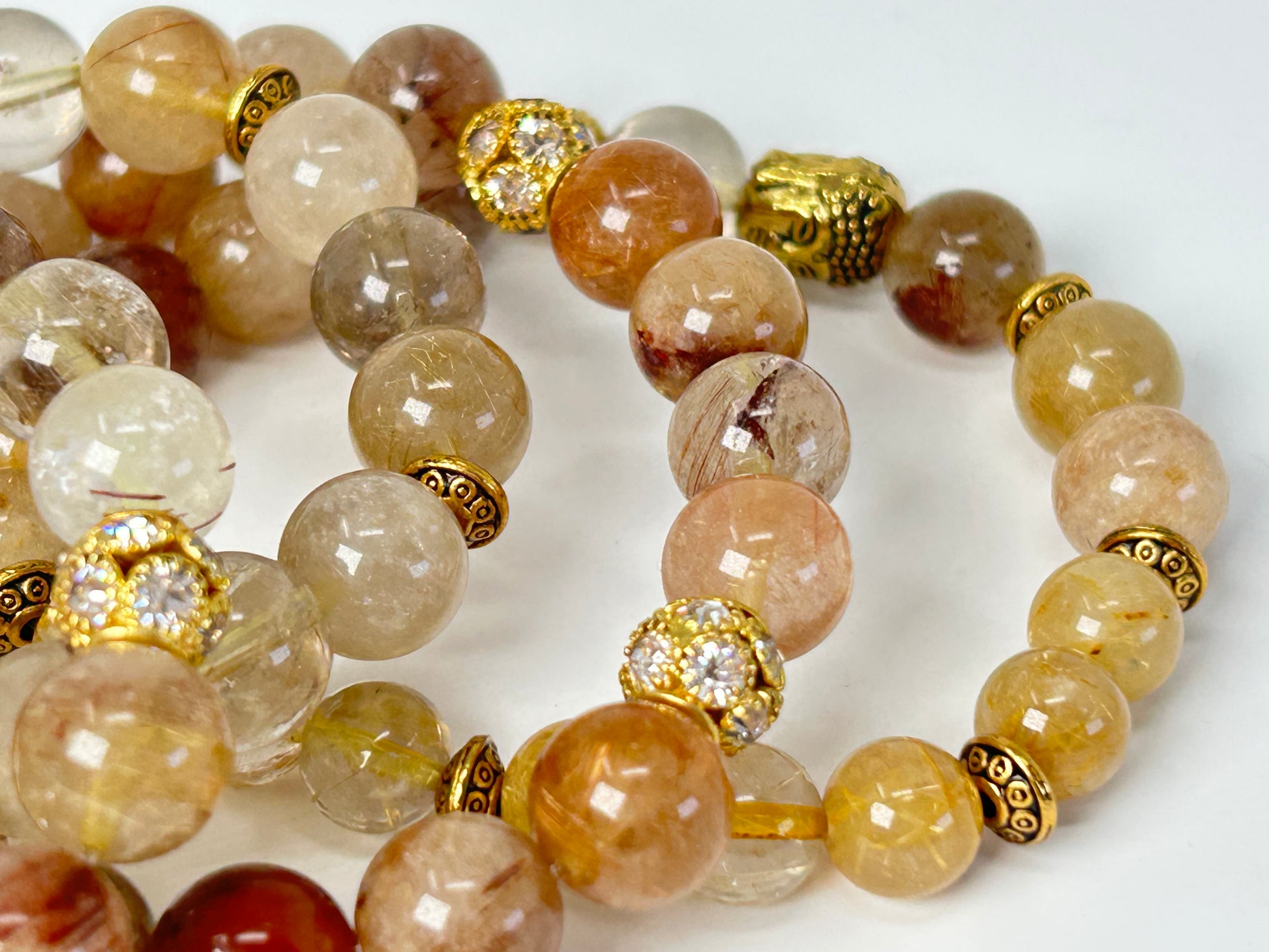 Close up of a Rutile Quartz Bracelets against a white background.