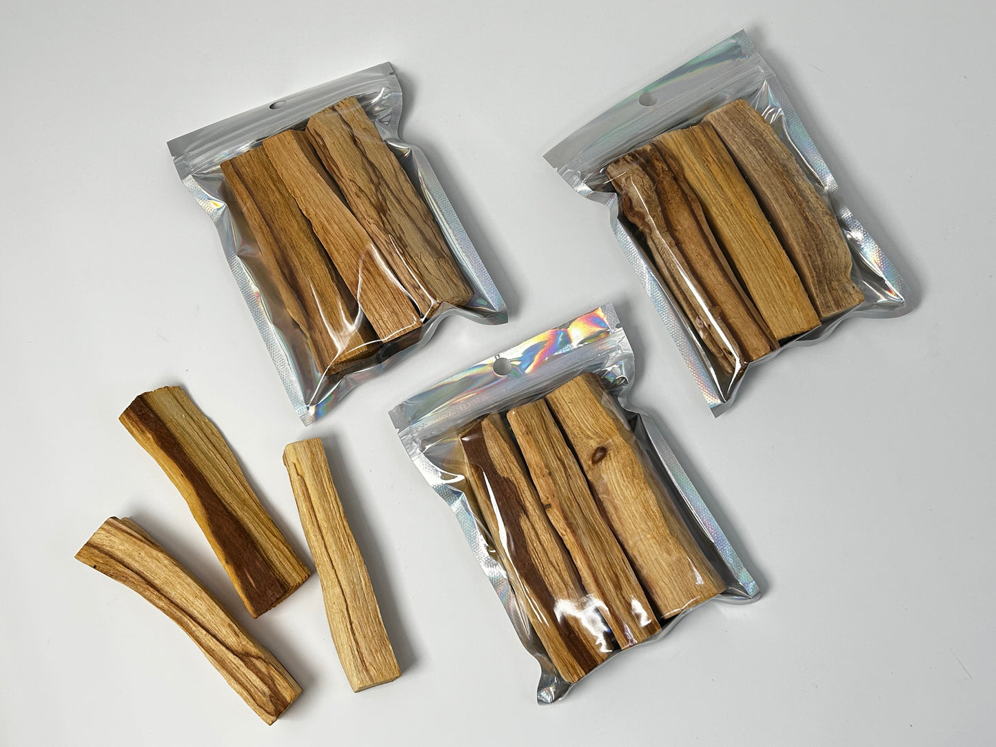 Packs of Sacred Wood Palo Santo Sticks on table with white background.