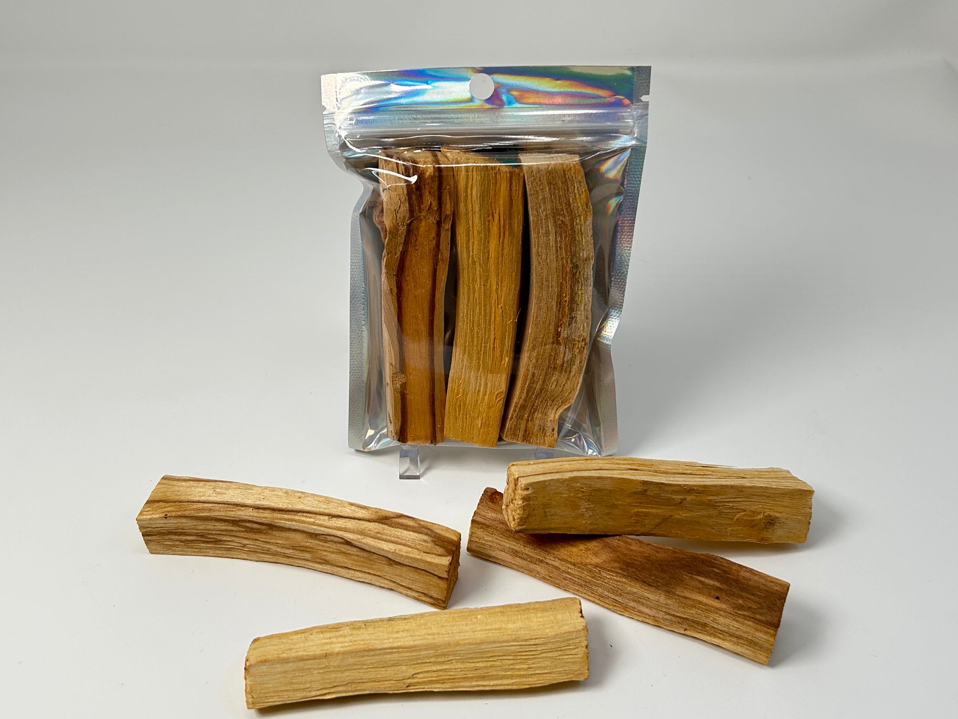 Packs of Sacred Wood Palo Santo Sticks for natural grounding on table with white background.
