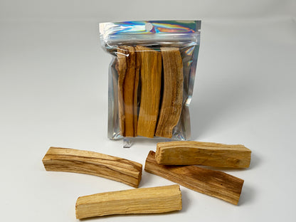 Packs of Sacred Wood Palo Santo Sticks for natural grounding on table with white background.