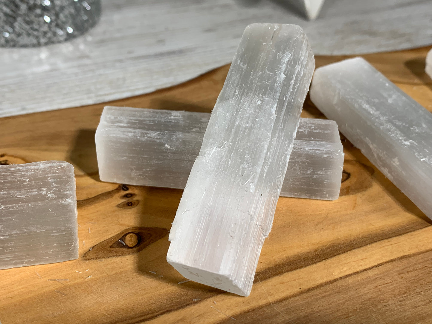 Selenite Crystal Cleansing Stick to Purify and Protect for energy and trust on a wooden table-top 