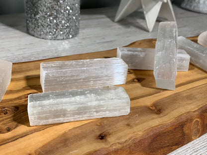 Selenite Crystal Cleansing Stick to Purify and Protect for energy and trust on a wooden table-top