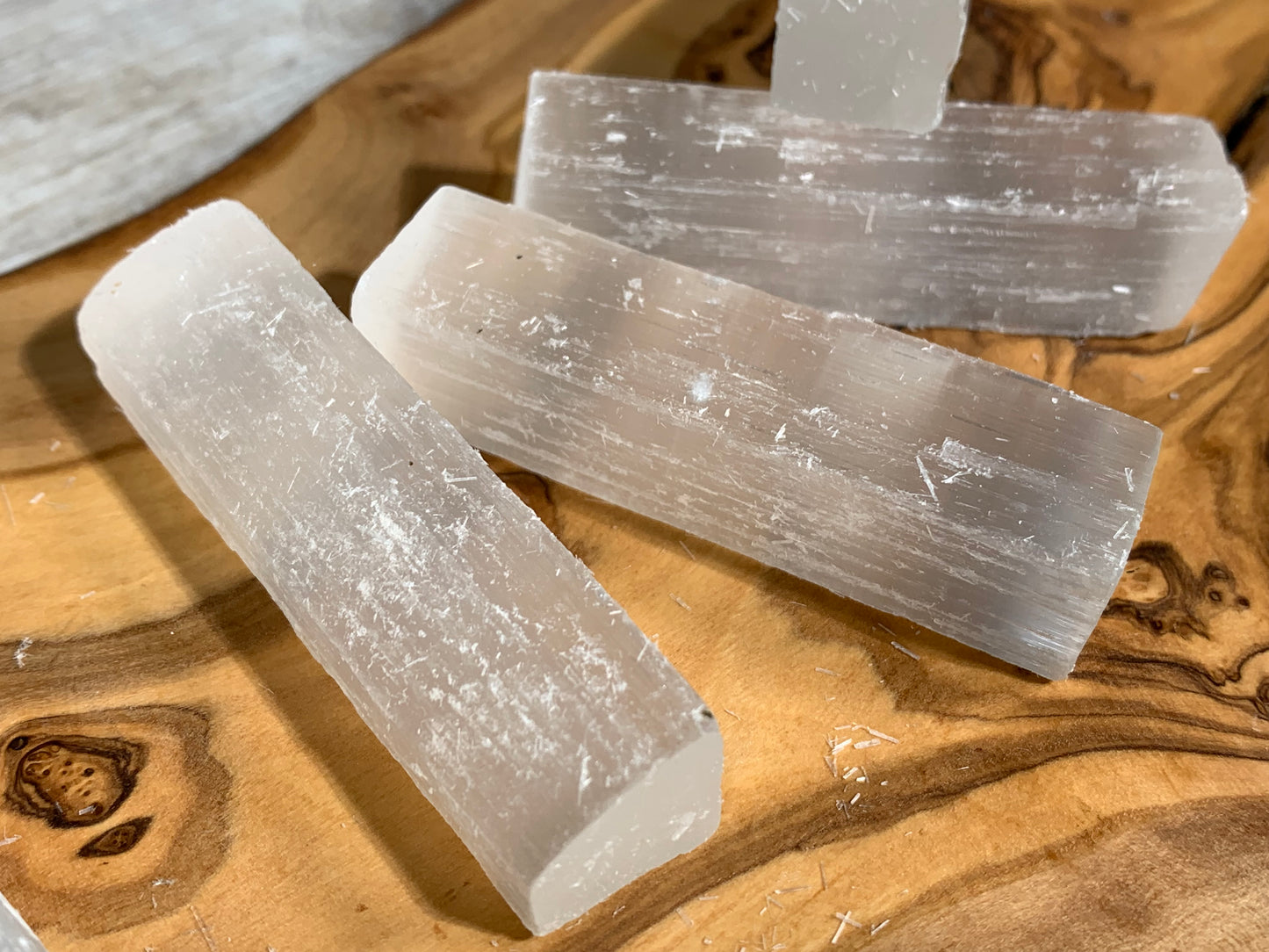 Selenite Crystal Cleansing Stick to Purify and Protect for energy and trust on a wooden table-top
