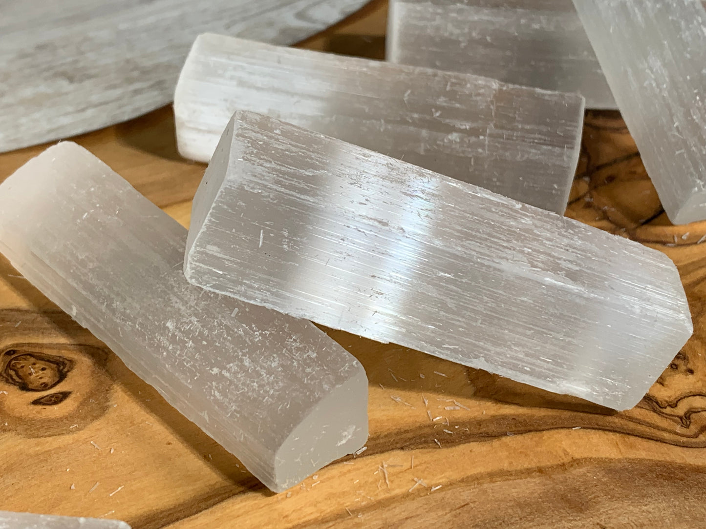 Selenite Crystal Cleansing Stick to Purify and Protect for energy and trust on a wooden table-top