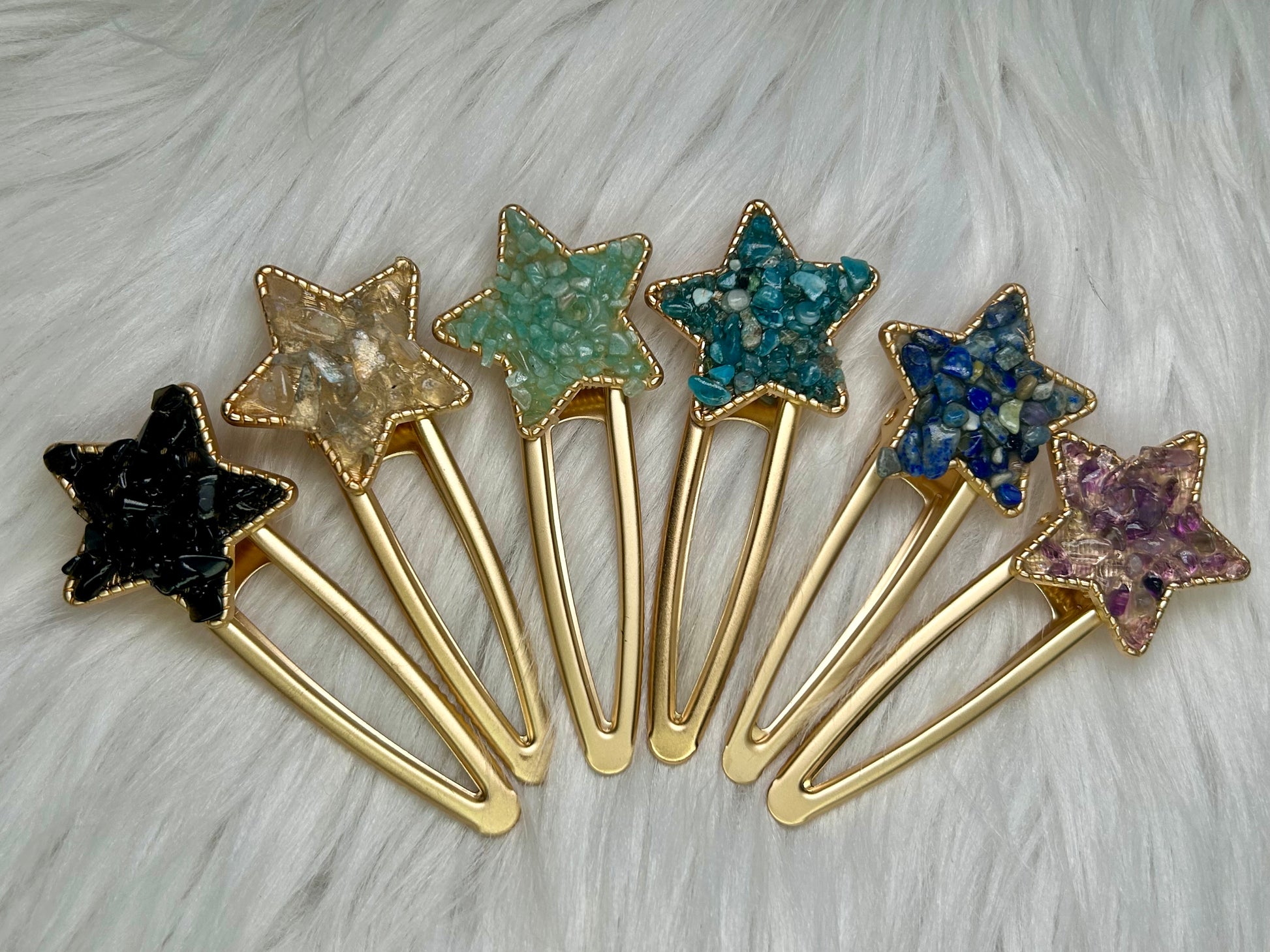 Star-shaped hair clips with gold bases on a textured white background